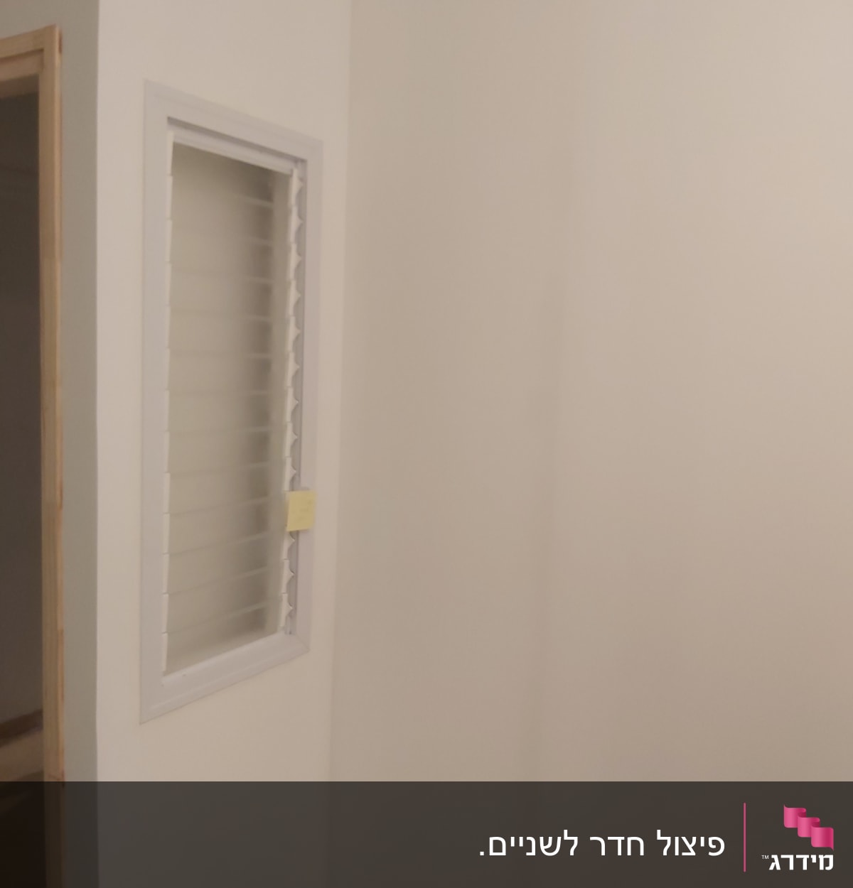 קיר גבס עם חלון קטן ותריסים